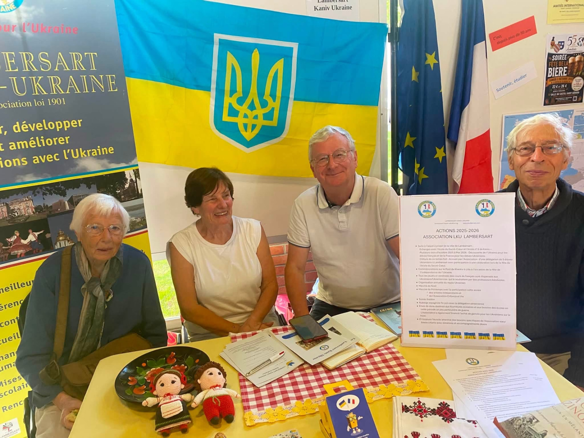 Les bénévoles de Lambersart Kaniv Ukraine derrière le stand de l’association, devant le drapeau ukrainien.