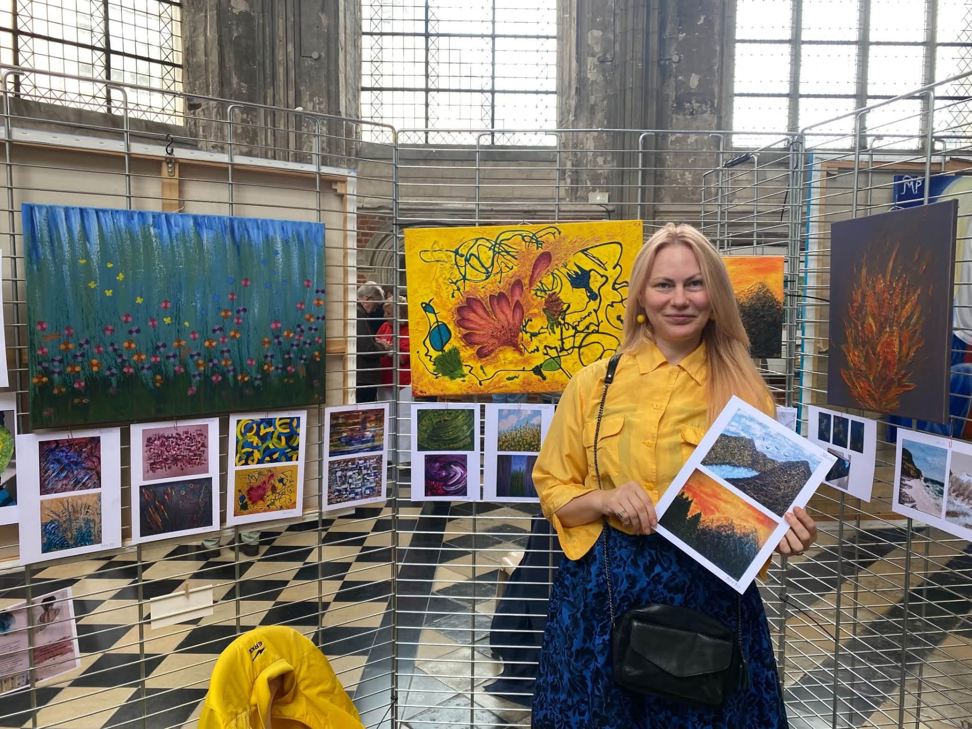 Une participante devant des tableaux aux couleurs vives.